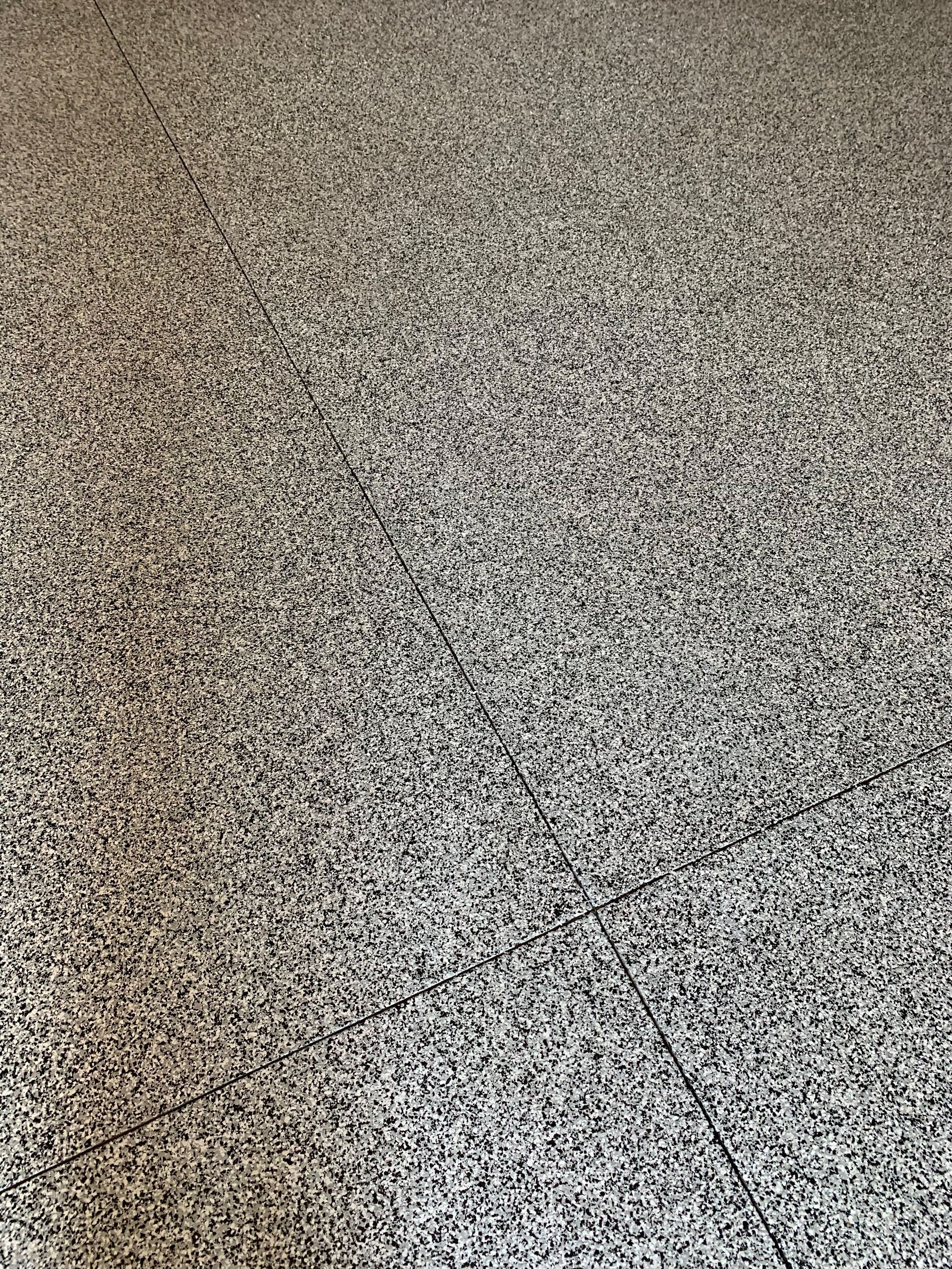 A close up of a carpeted floor with a lot of small stones on it.
