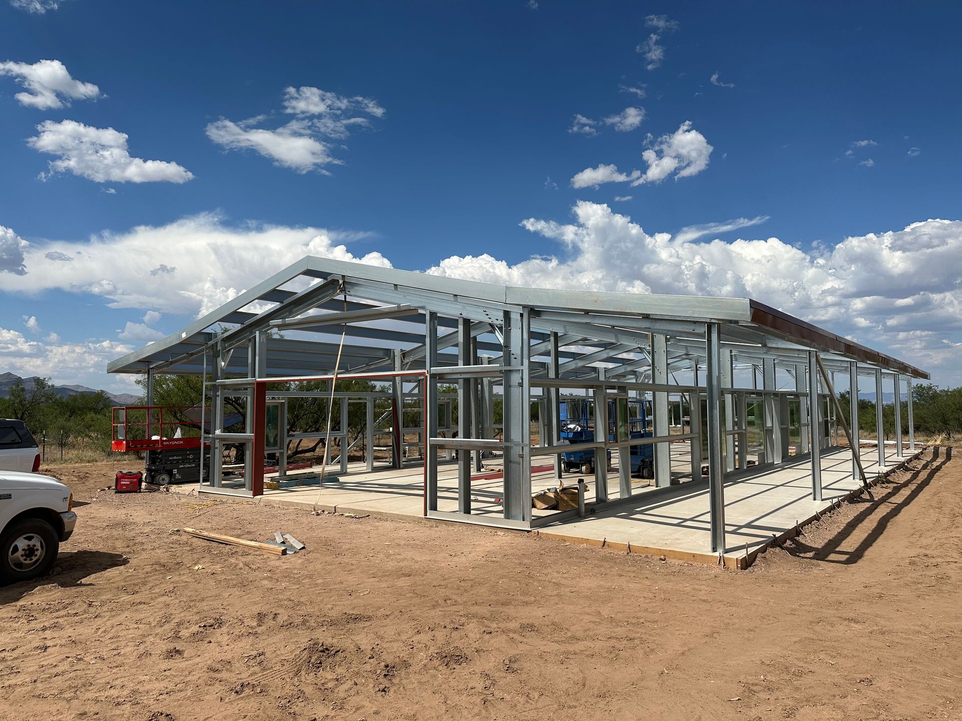 A white truck is parked in front of a building under construction.