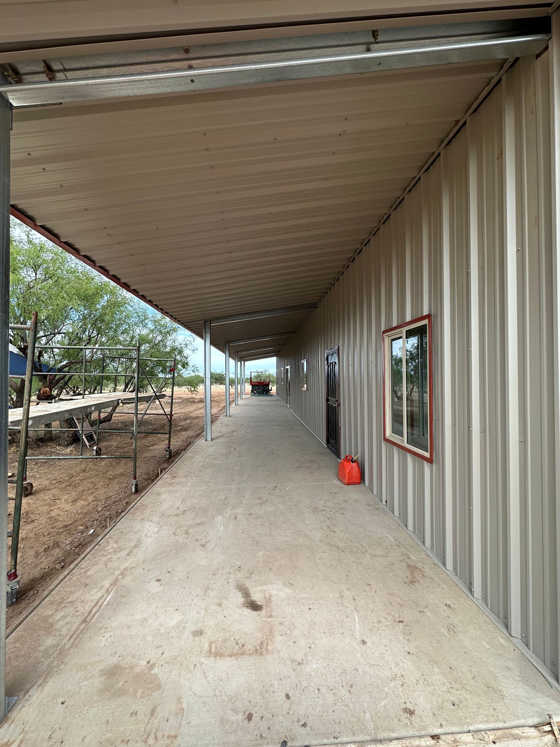 A long hallway leading to a building with a covered walkway.