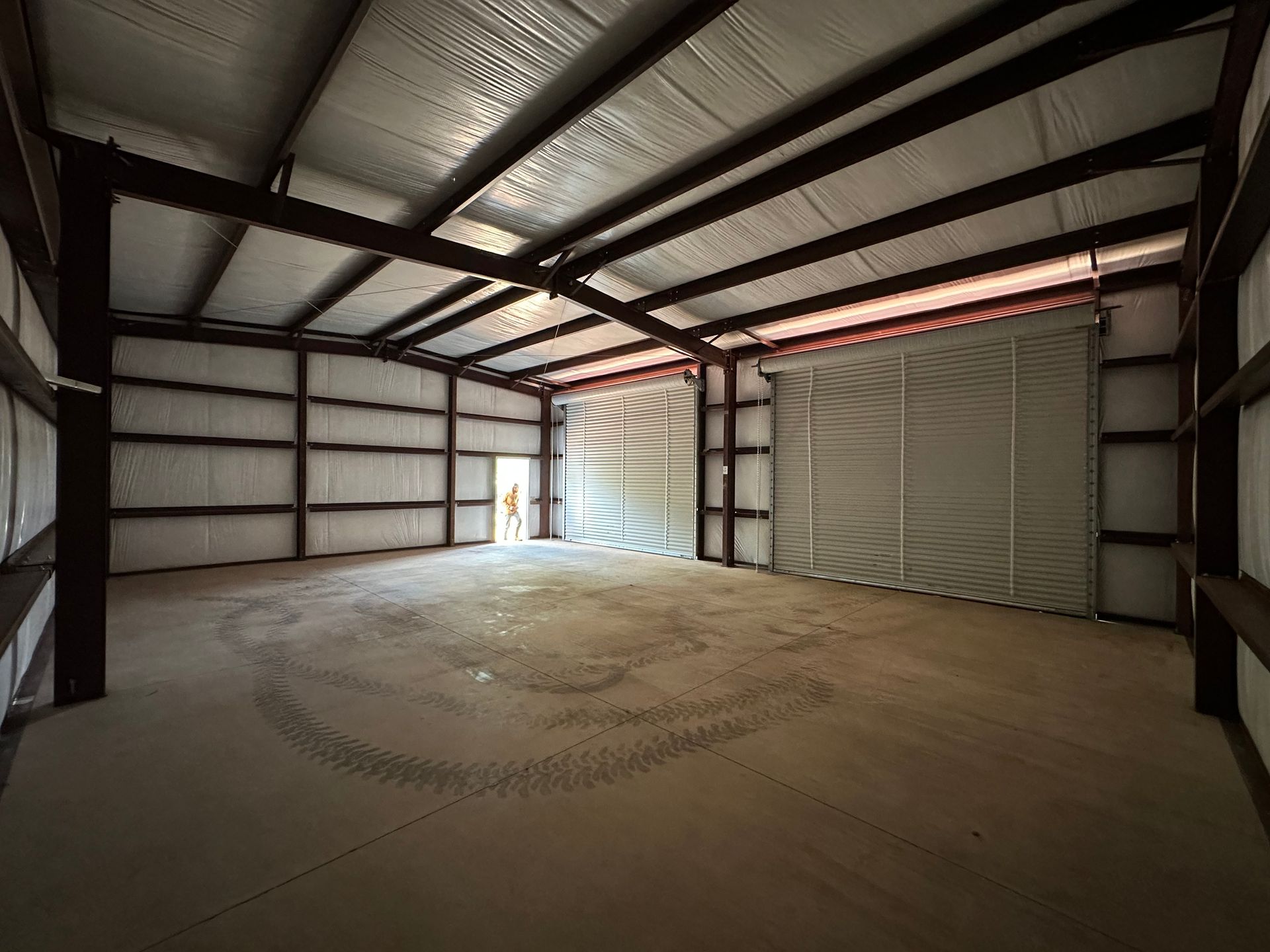 A large empty warehouse with a sliding door in the middle.