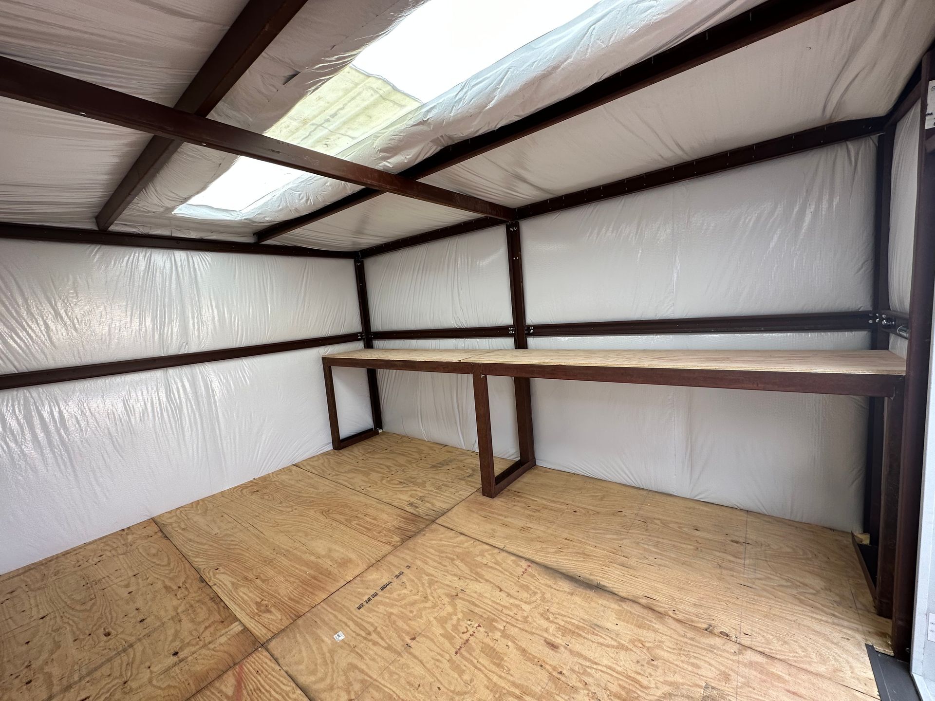 An empty room with a wooden table and a skylight.