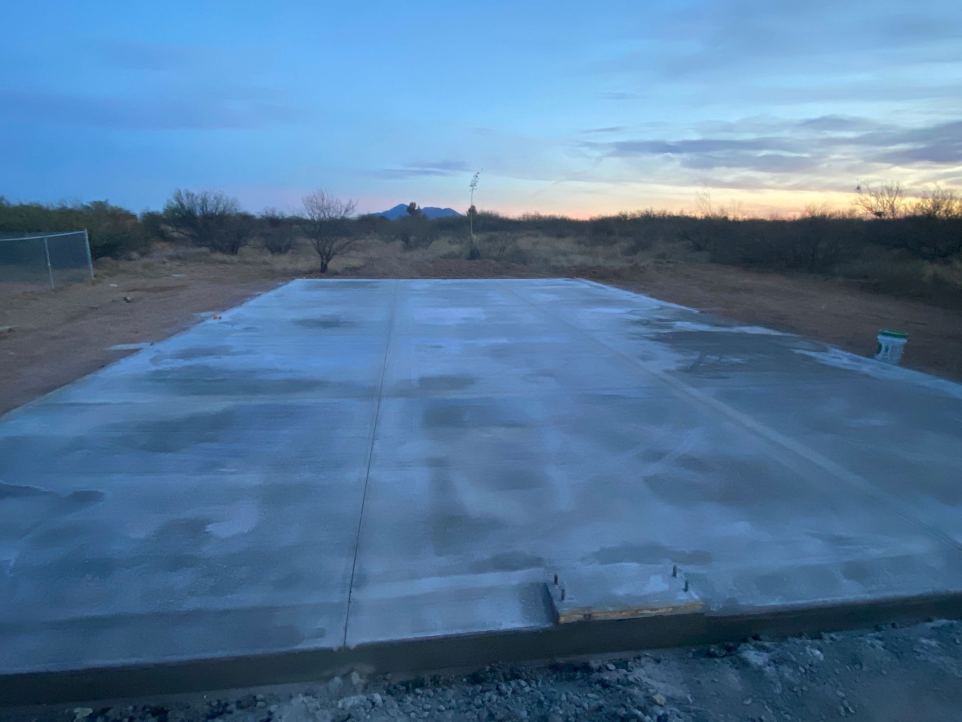 A large concrete slab is sitting in the middle of a dirt field.