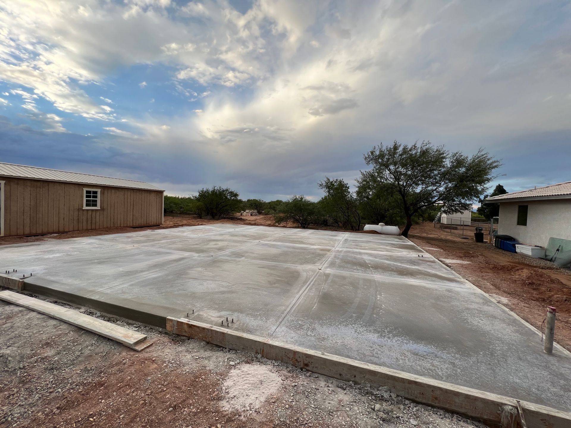 A concrete driveway is being built in front of a house.
