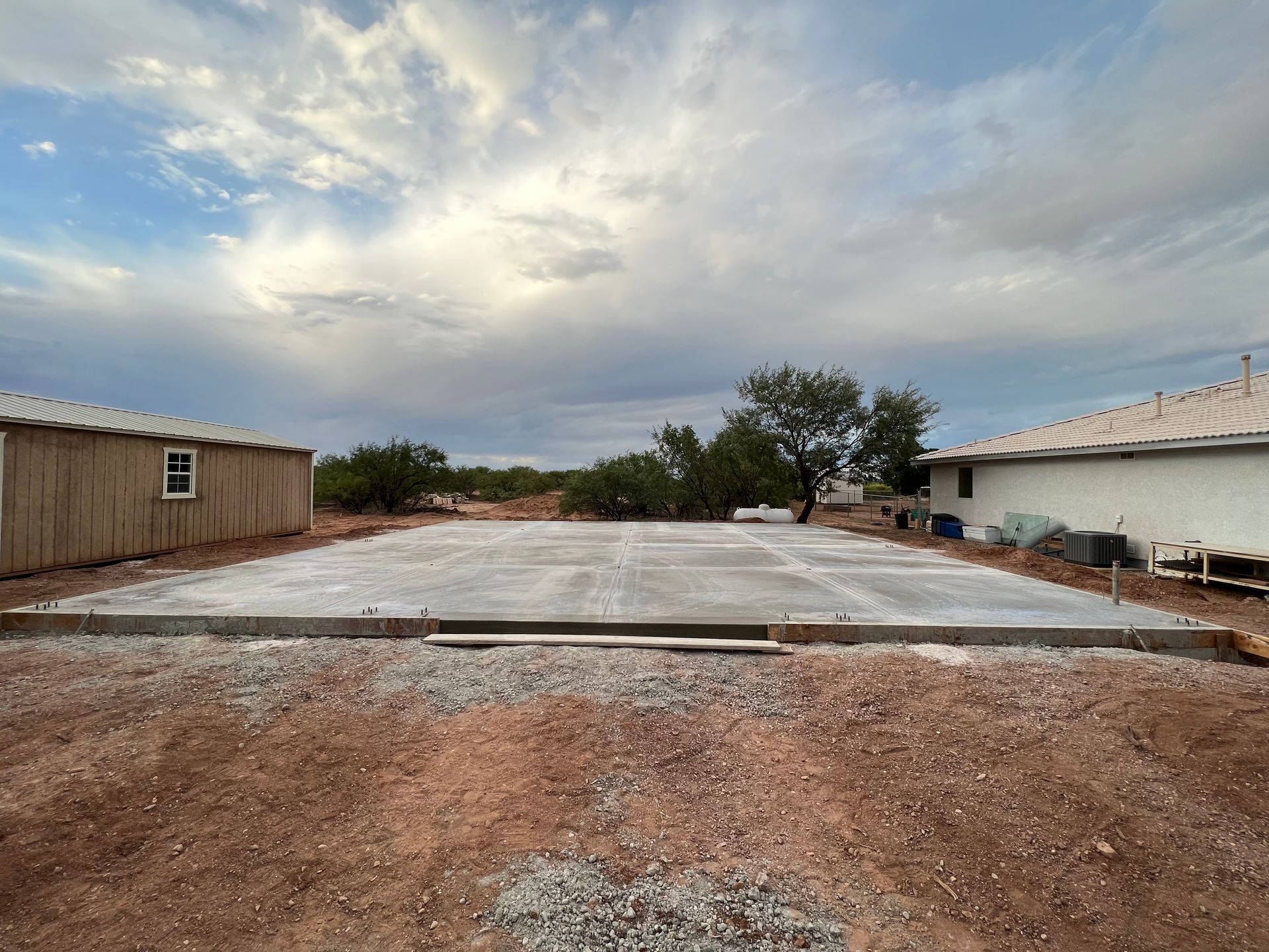 A large concrete slab is sitting in the middle of a dirt field.
