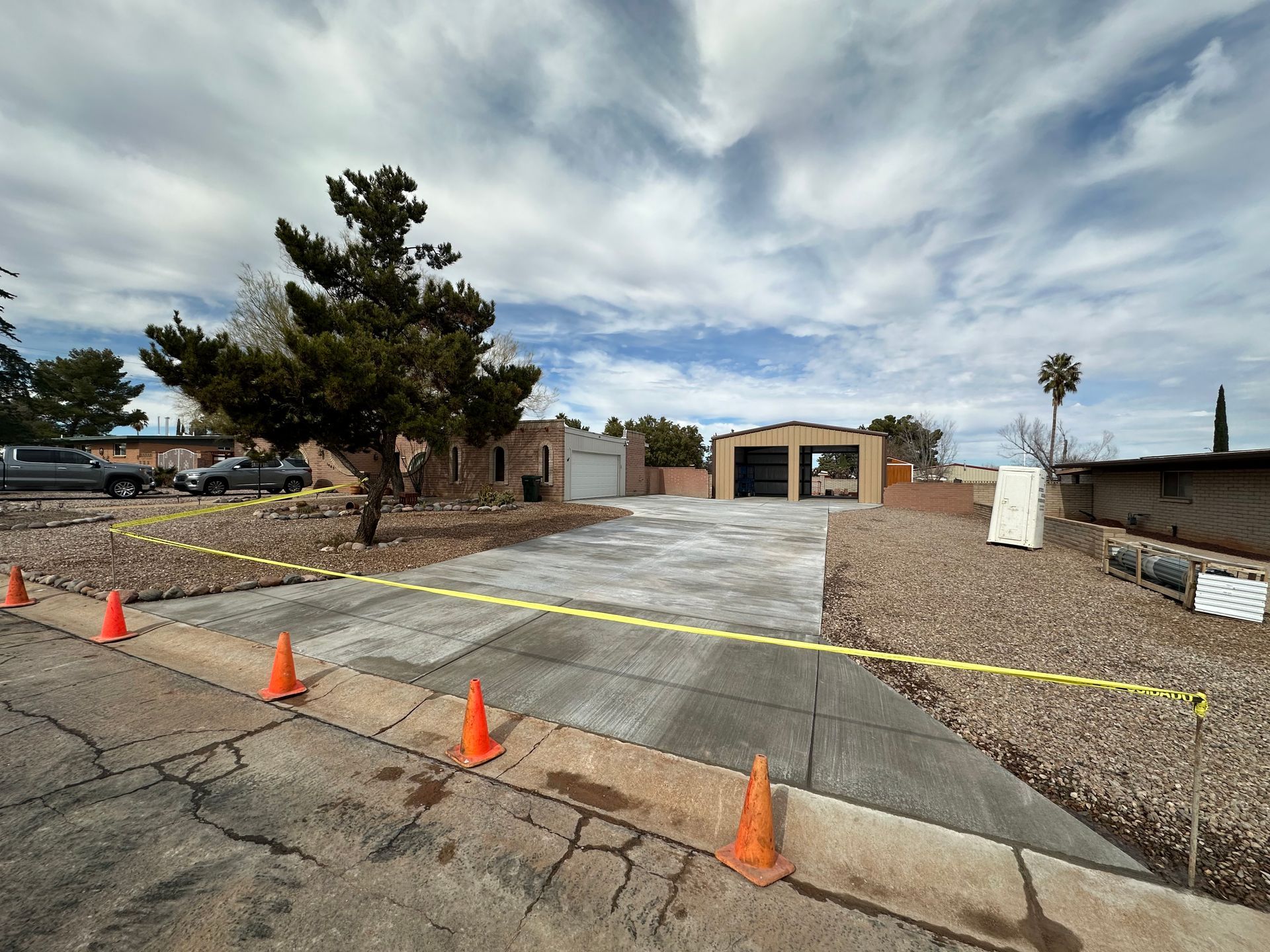 A concrete driveway is being built in front of a house