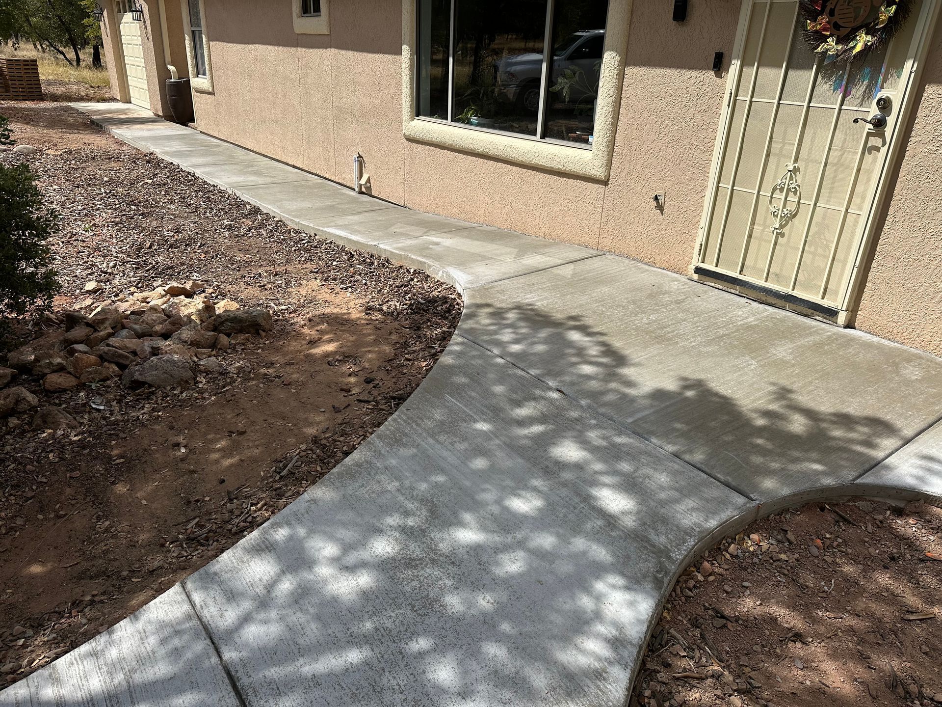 A concrete walkway leading to the front door of a house.