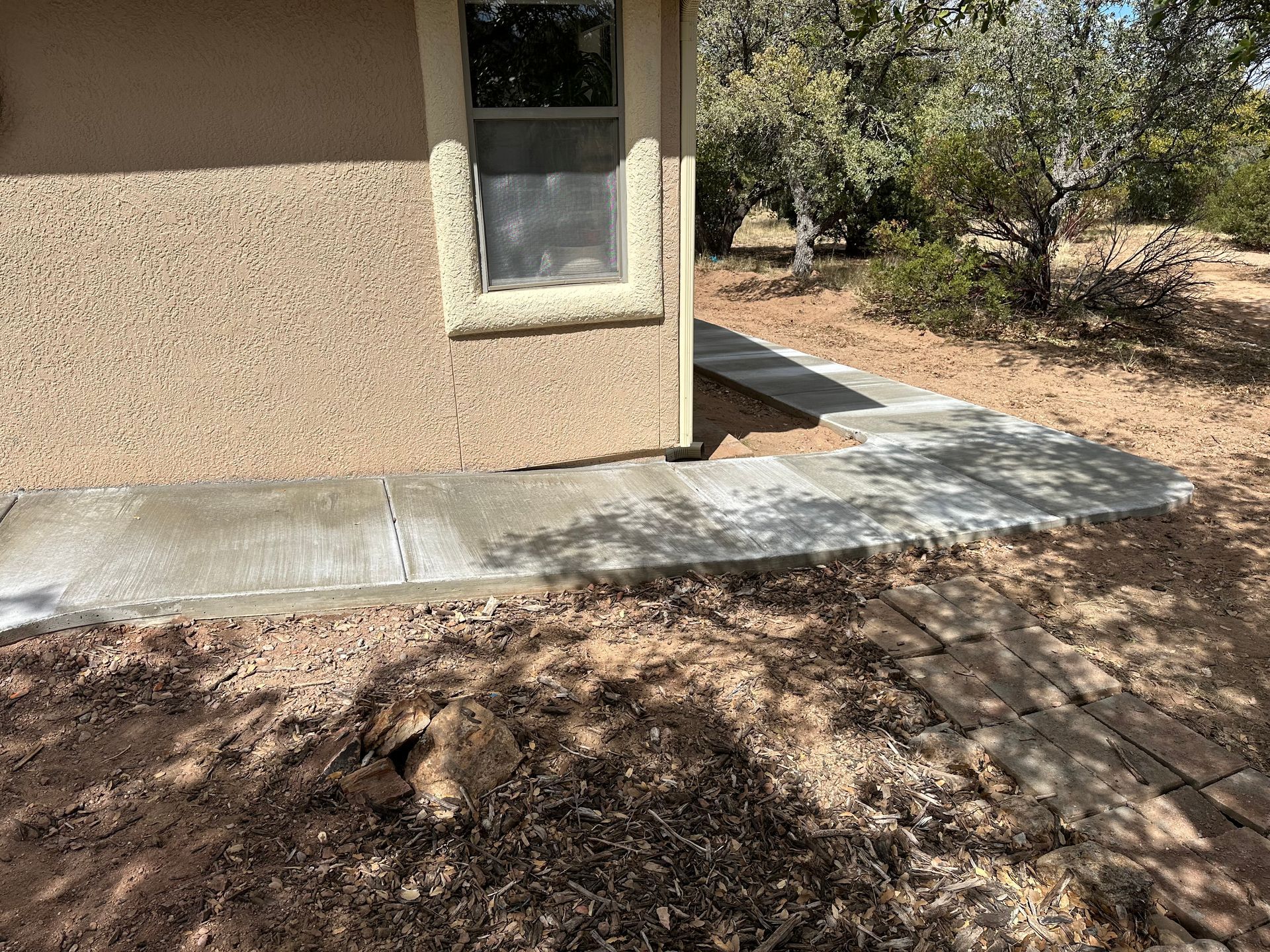 A concrete walkway is being built in front of a house.