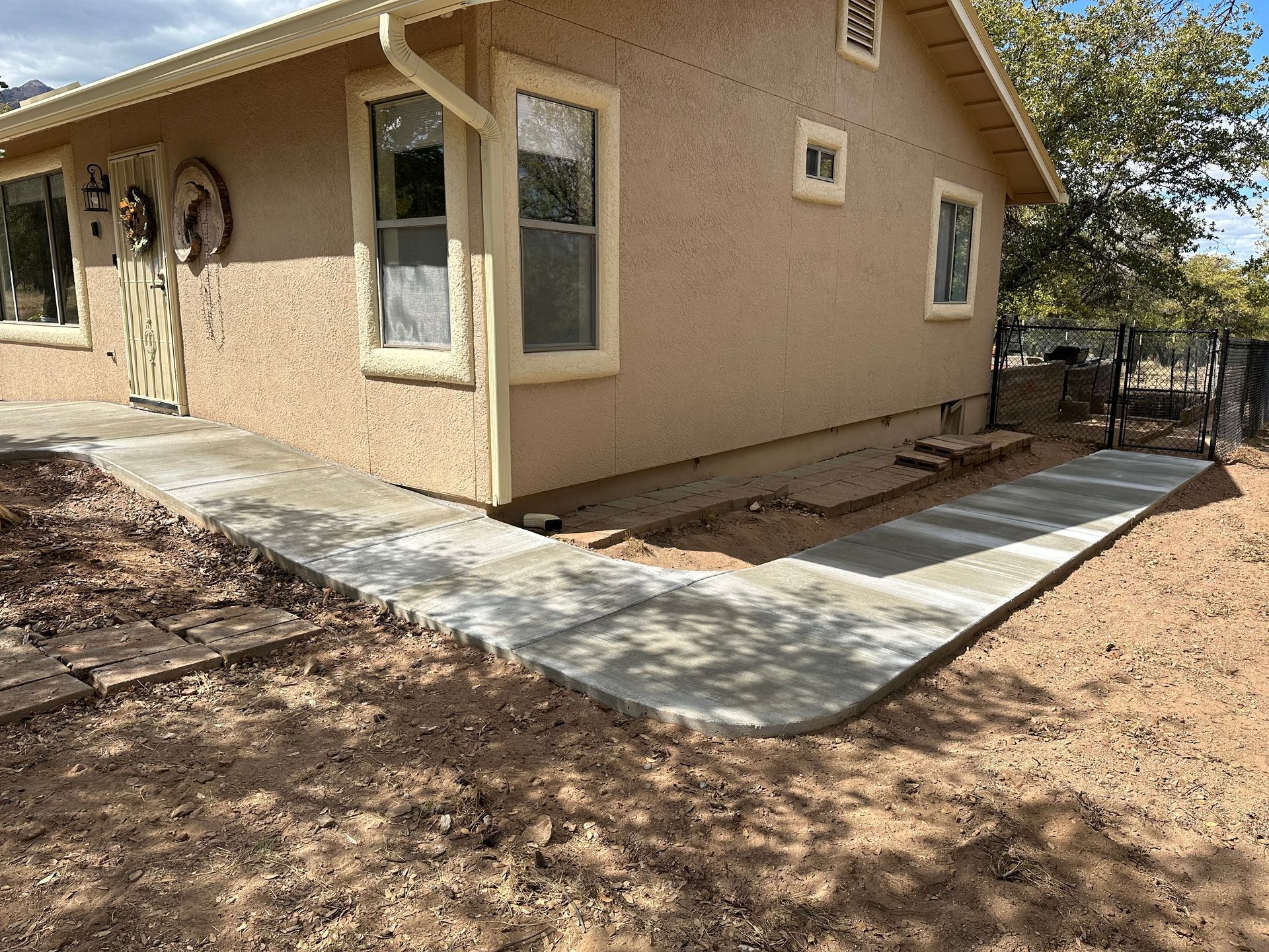 A house with a concrete walkway leading to it.