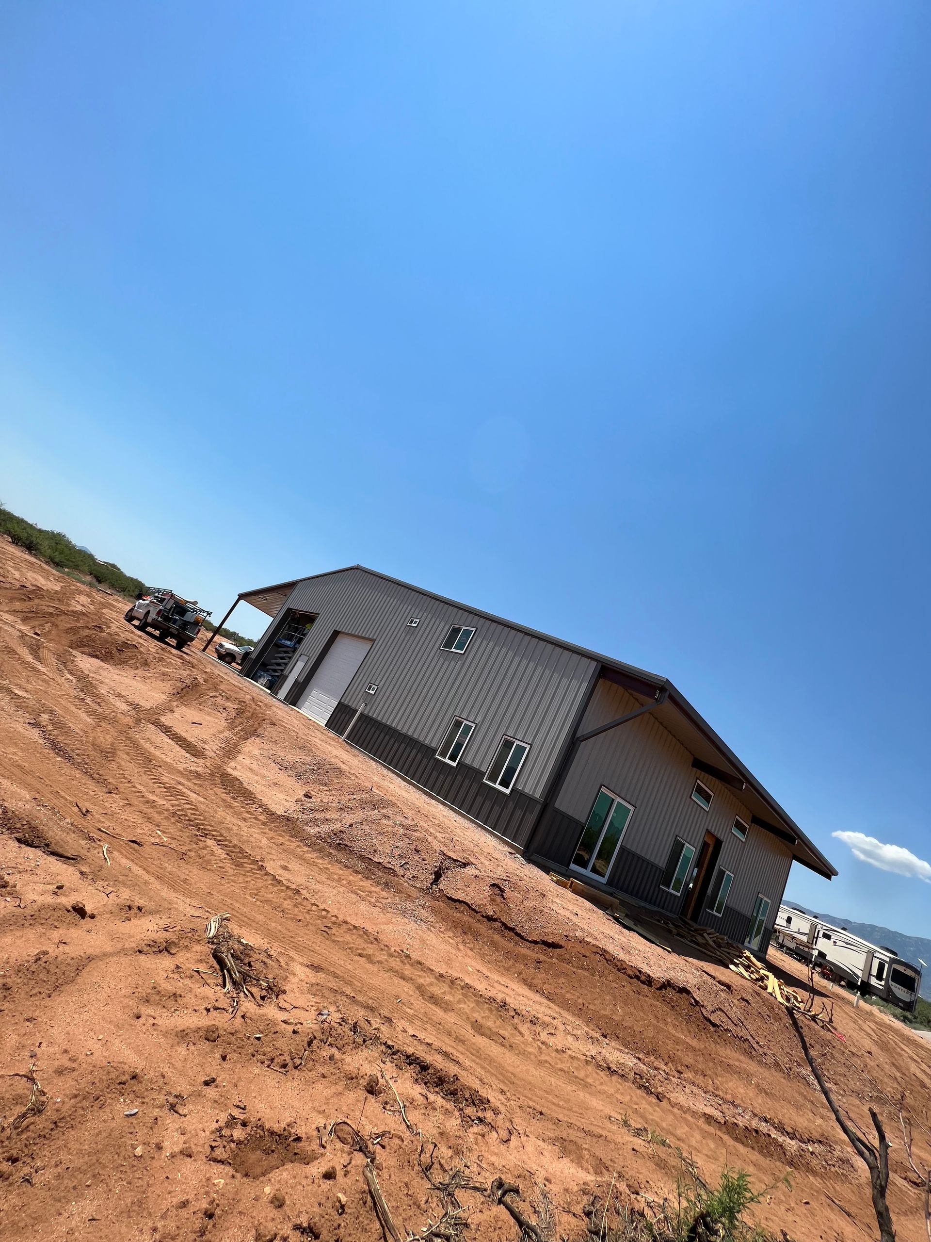 A house is being built in the middle of a dirt field.
