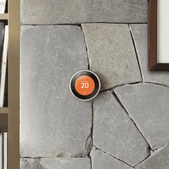 A thermostat on a stone wall with the number 20 on it