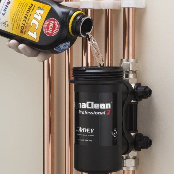 A bottle of mc7 protector is being poured into a copper pipe
