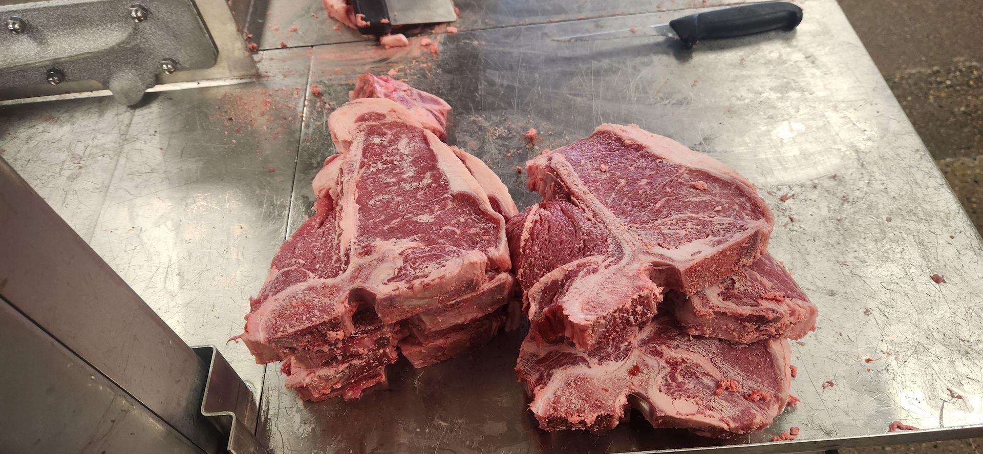 Two pieces of raw meat are sitting on a cutting board.