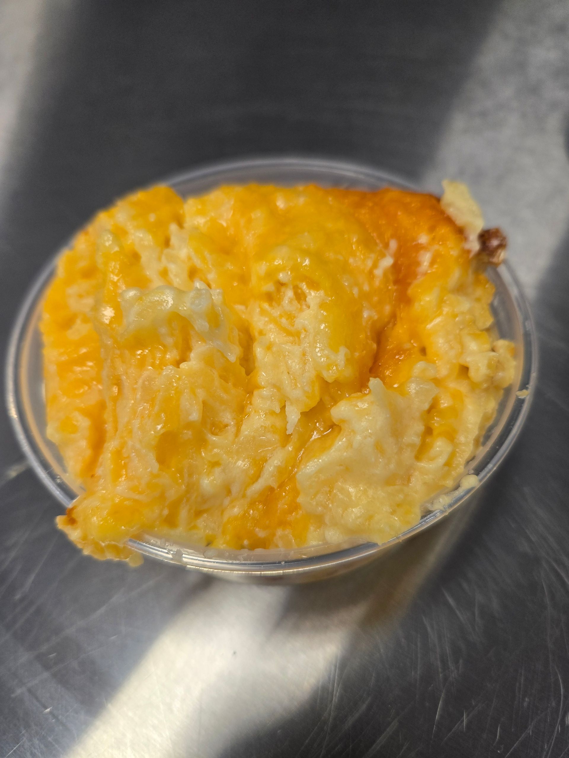 A close up of a bowl of macaroni and cheese on a table.