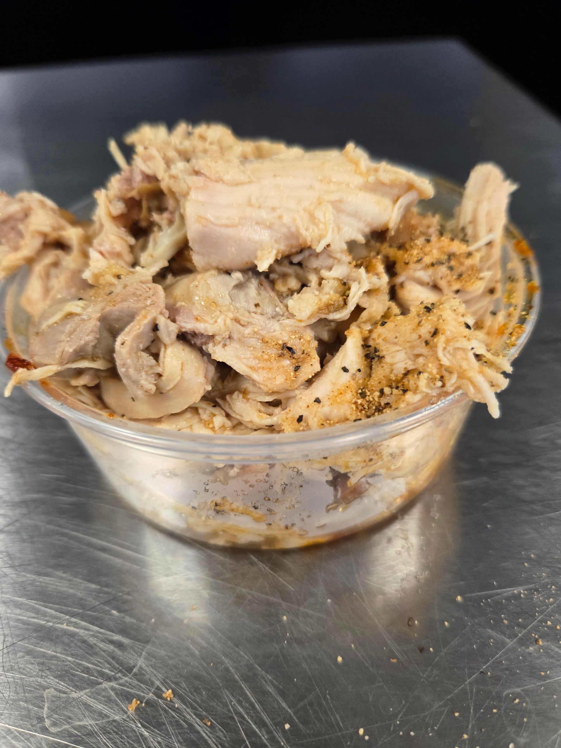 A bowl of shredded chicken is sitting on a table.