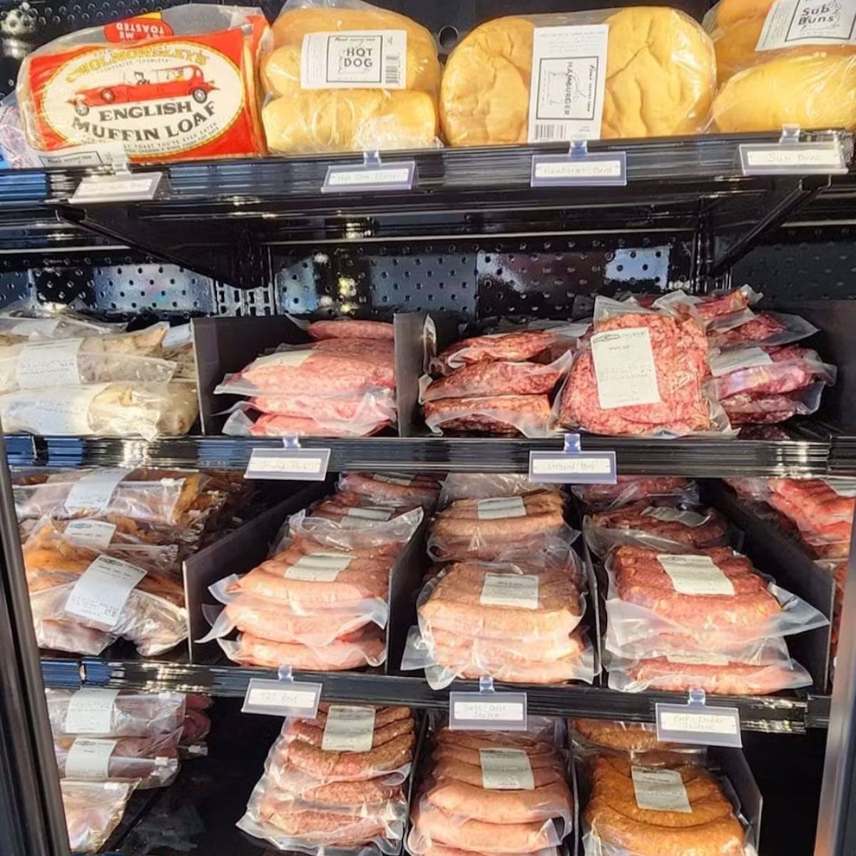A refrigerator filled with lots of food including a loaf of english muffin loaf