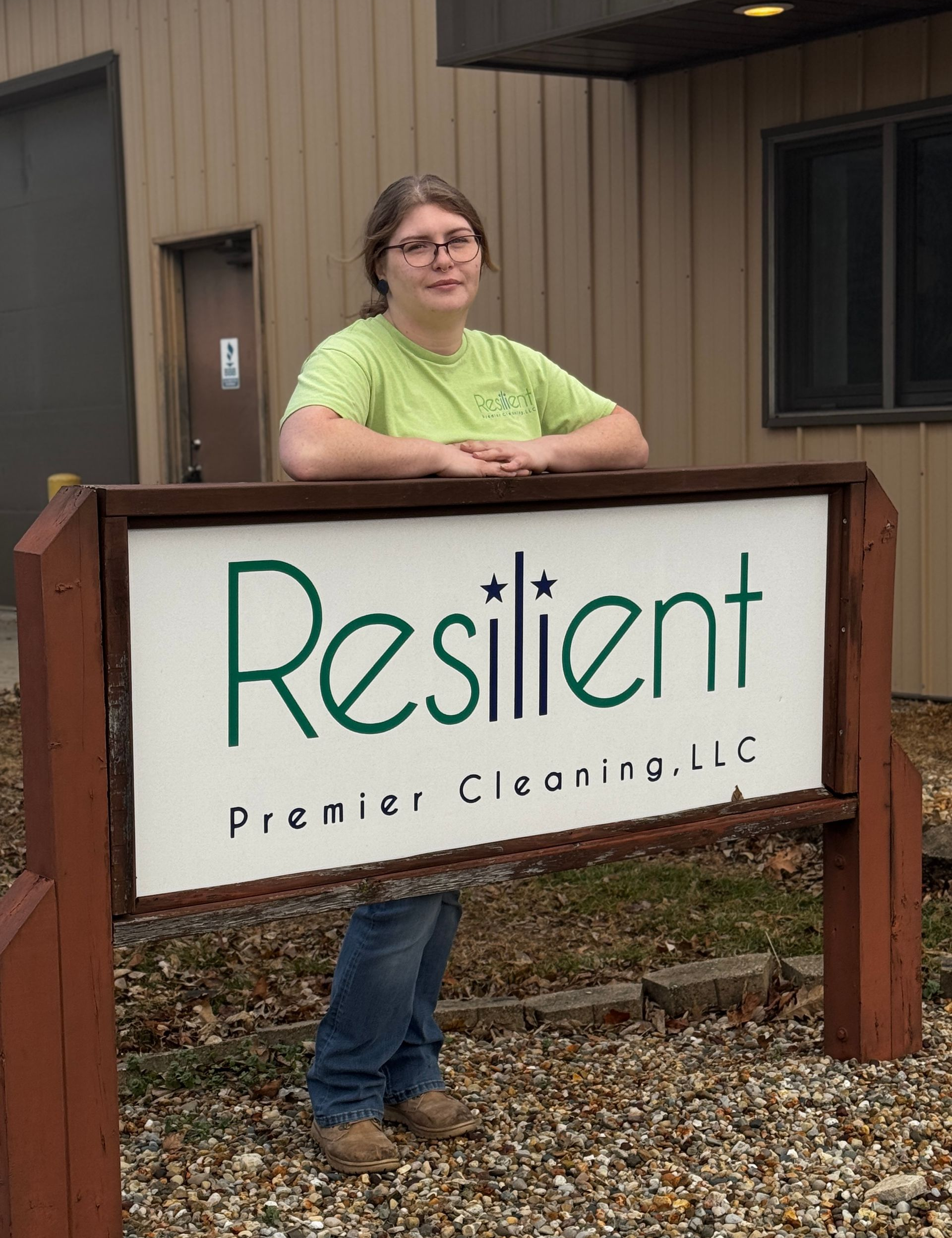Woman standing by a sign for 