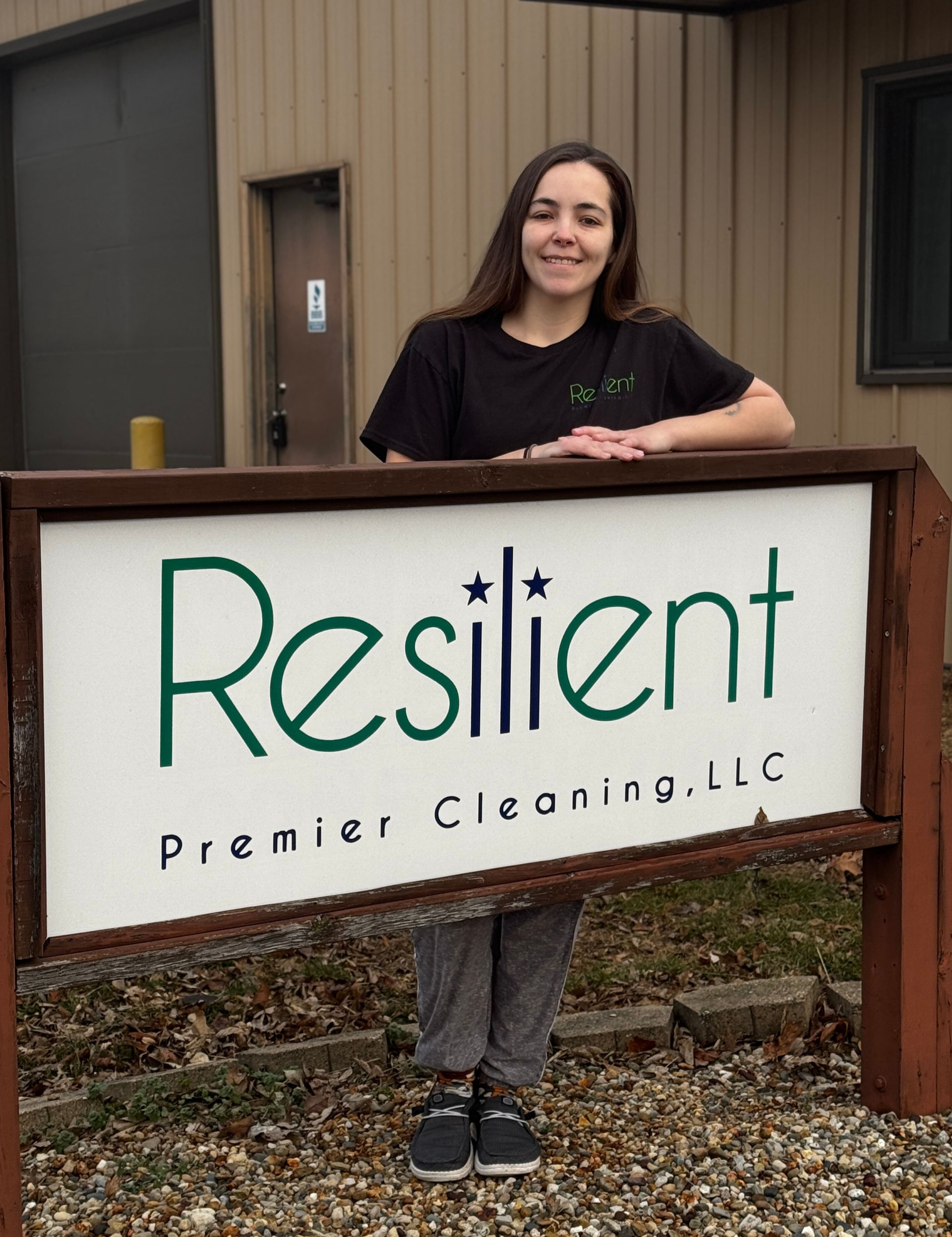 Woman standing behind a sign that reads 