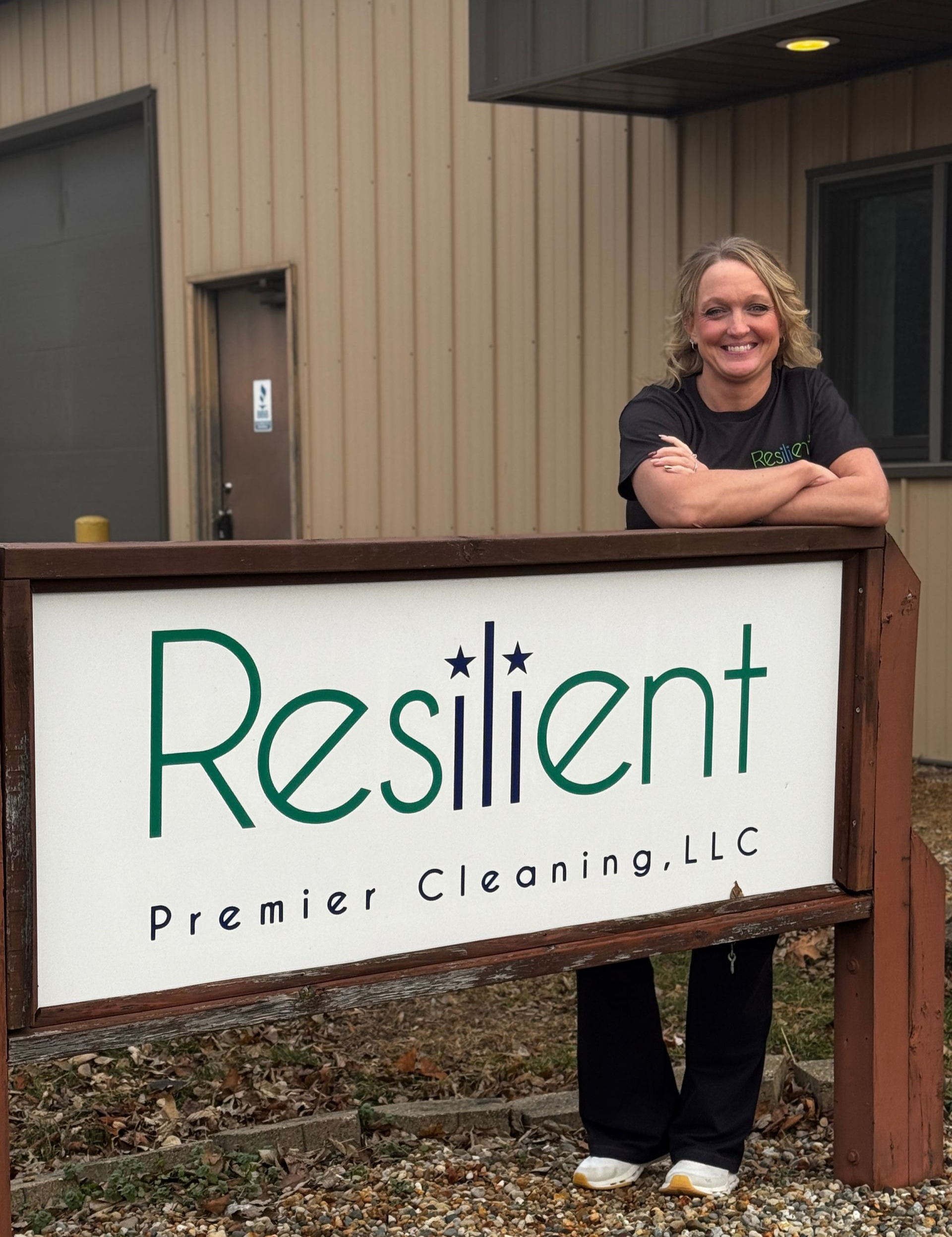 Woman stands by a sign for 