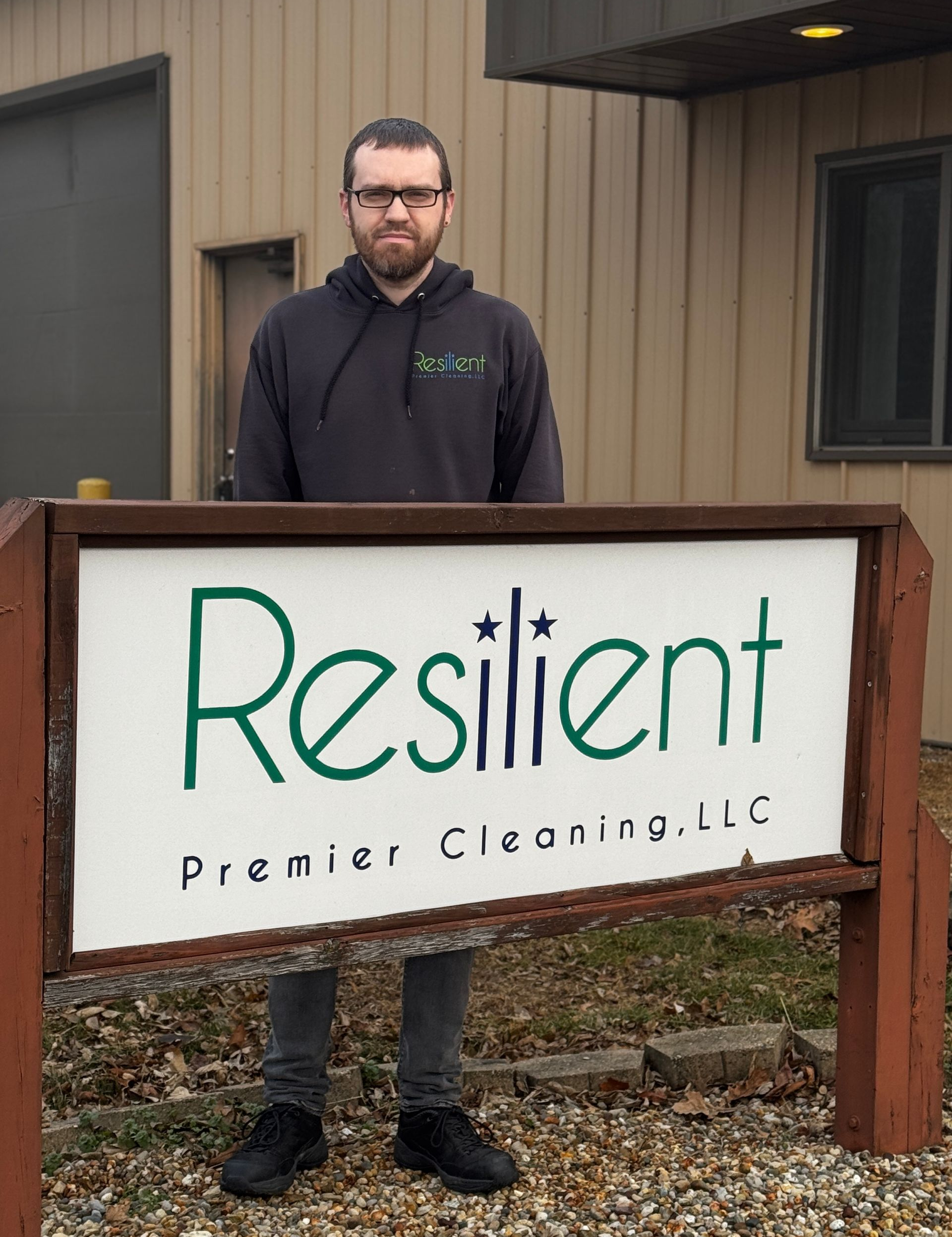 Man standing behind sign for 