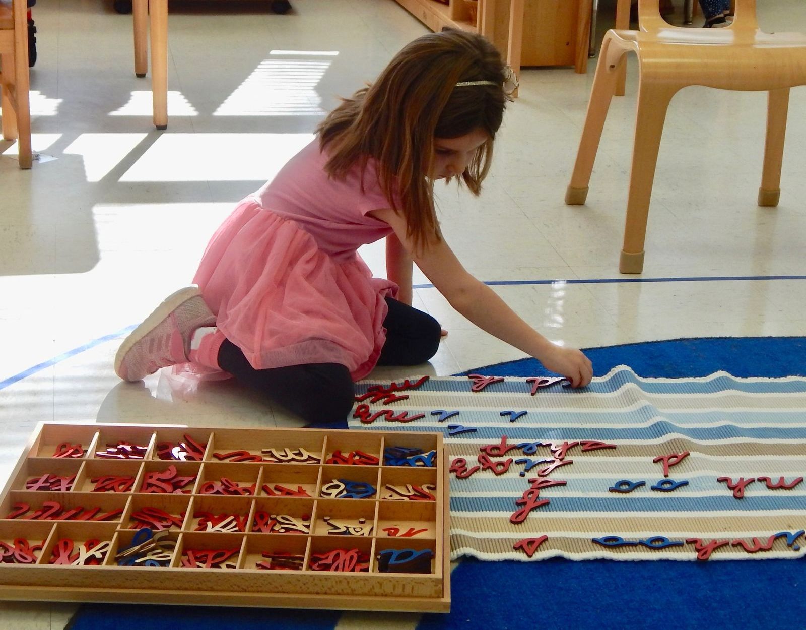 Child working with a Montessori language material