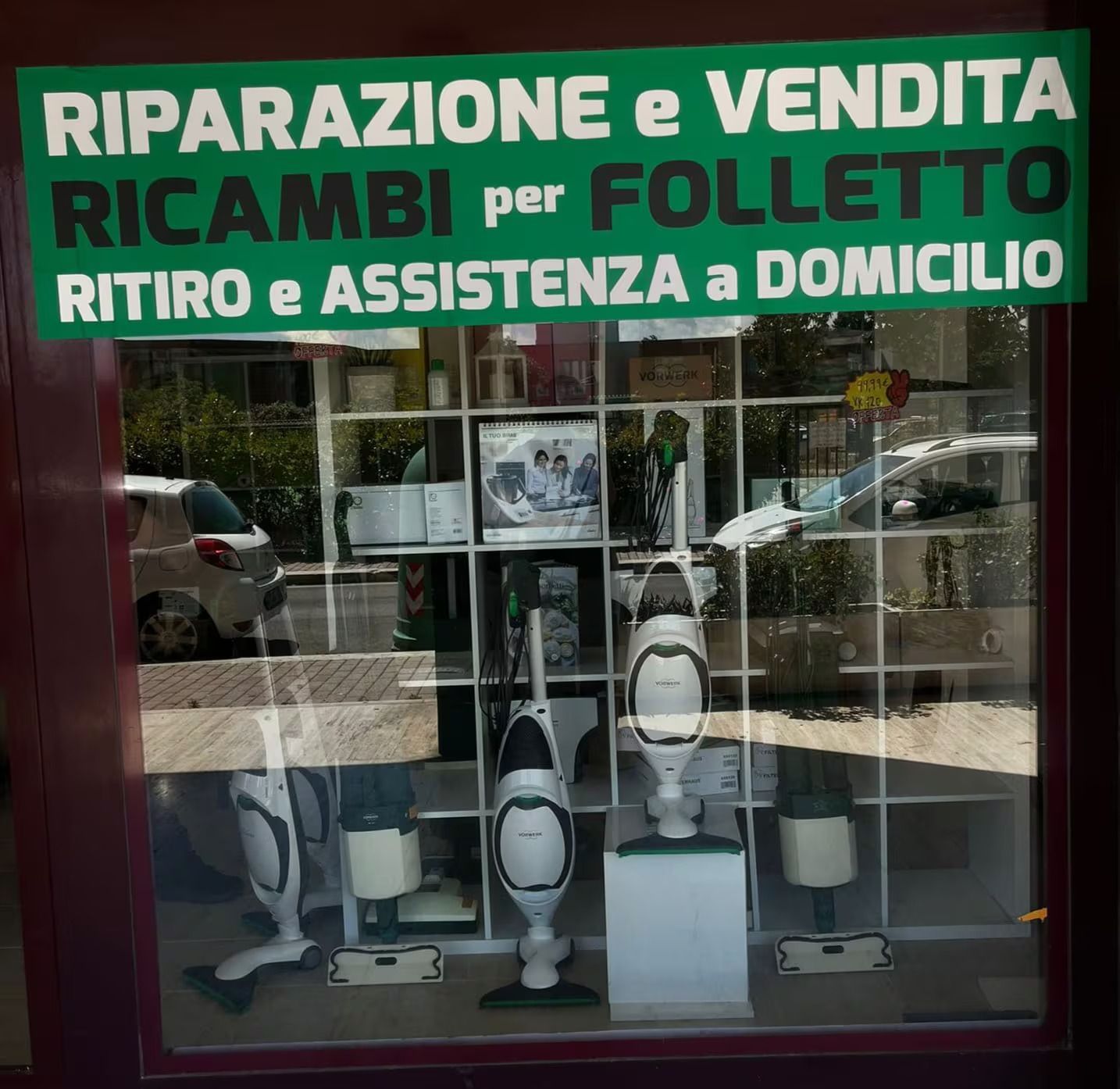 A store front with a green sign that says ' riparazione e vendita ricambi per folletto '