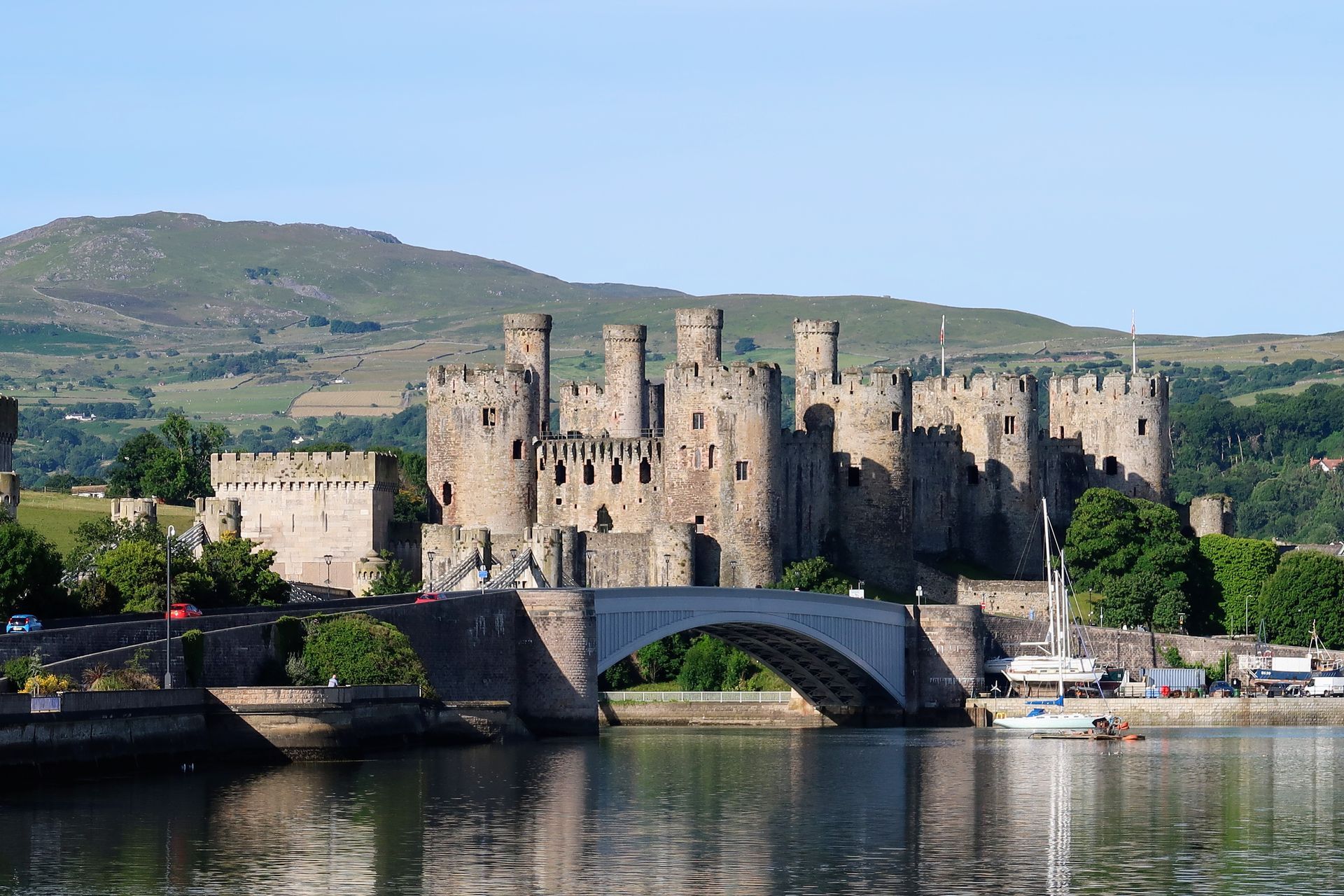 a large castle is sitting on top of a body of water next to a bridge .