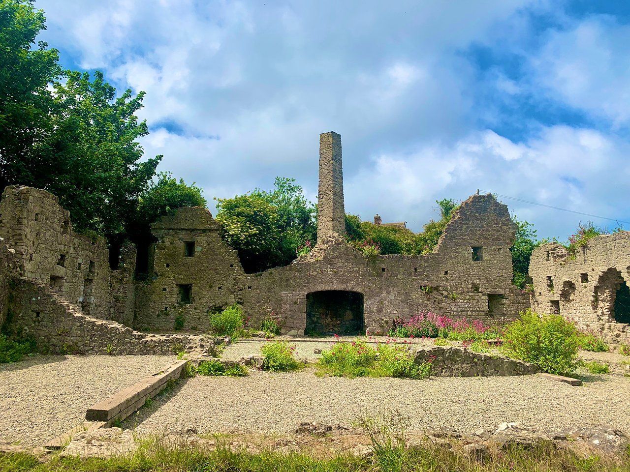 a large stone building with a chimney in the middle of it is surrounded by trees .