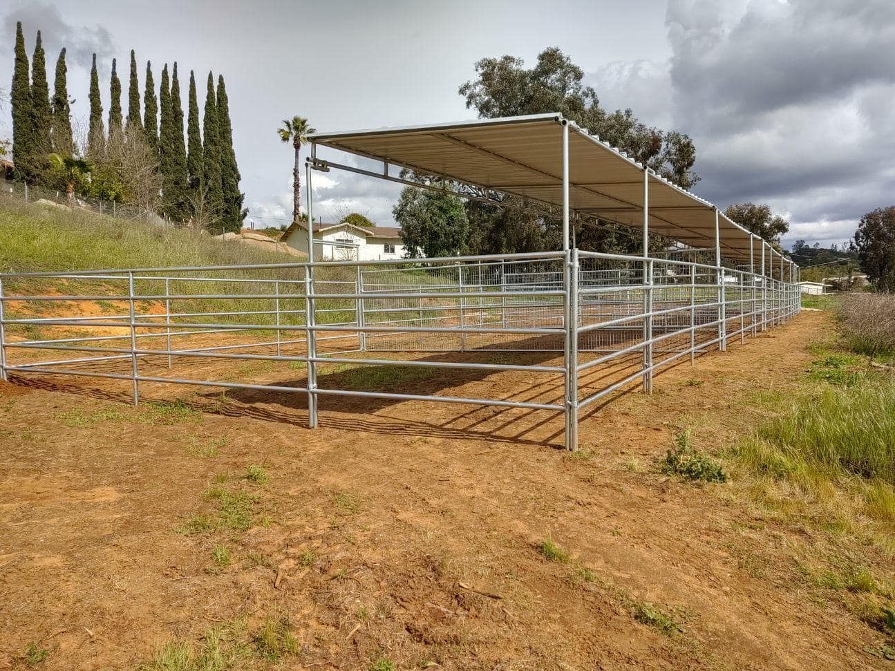 There is a fence in the middle of a field with a canopy over it.