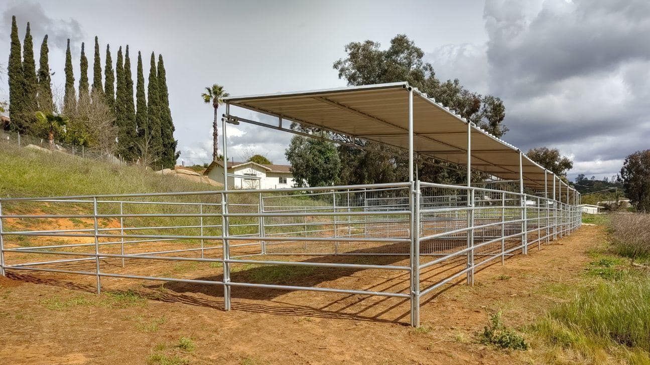 A metal fence with a canopy over it in a field.