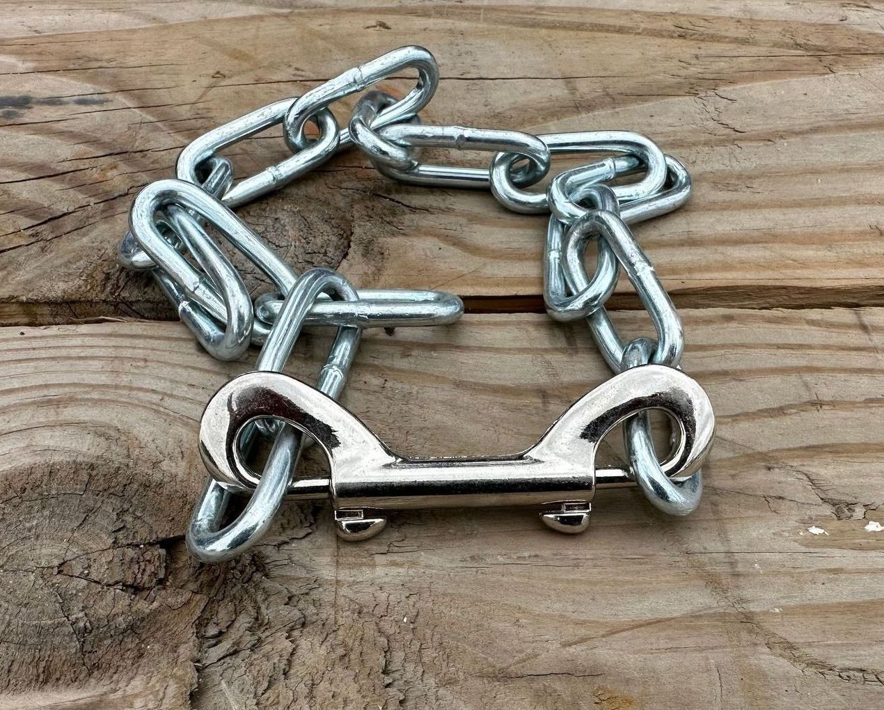 A chain is sitting on top of a wooden table.