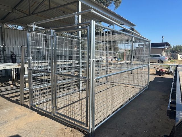 A large dog cage is sitting on top of a lush green lawn.