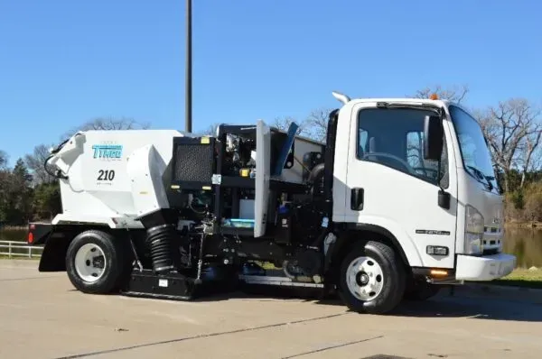 A white truck with the number 210 on the side is parked in a parking lot.
