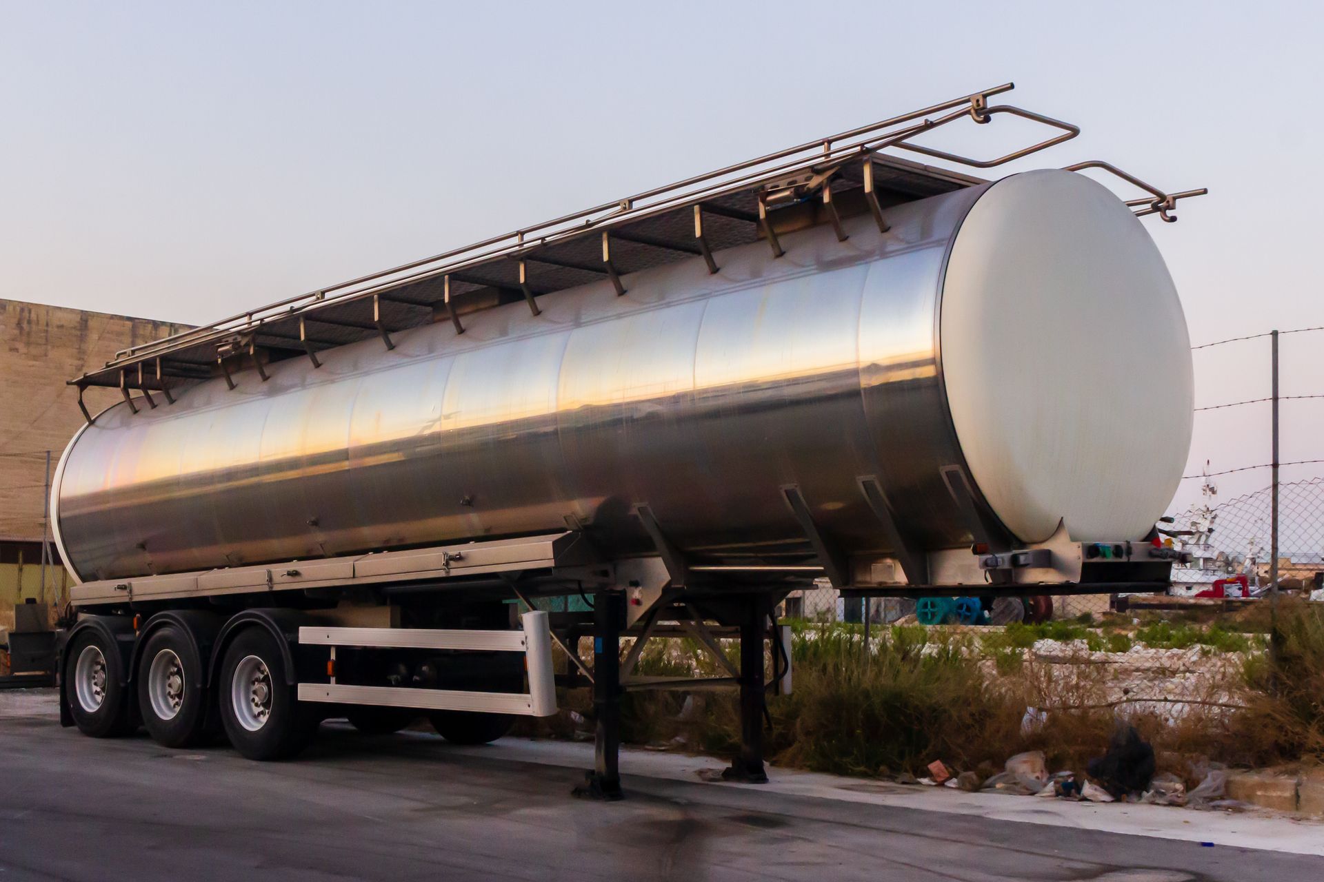 Close-up of a shiny steel tanker trailer parked outdoors, highlighting its industrial utility and design.