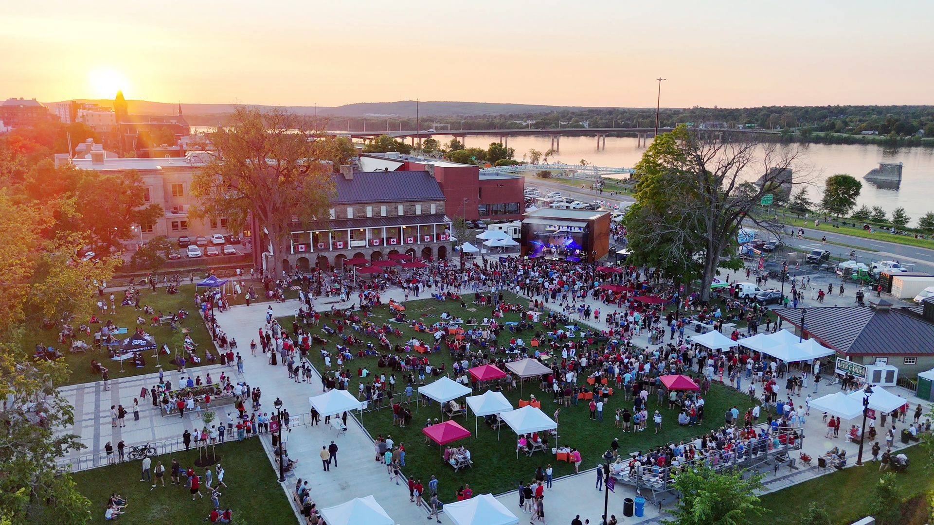 Glass skyscraper with red logo, street view, city buildings, dusk in Fredericton
