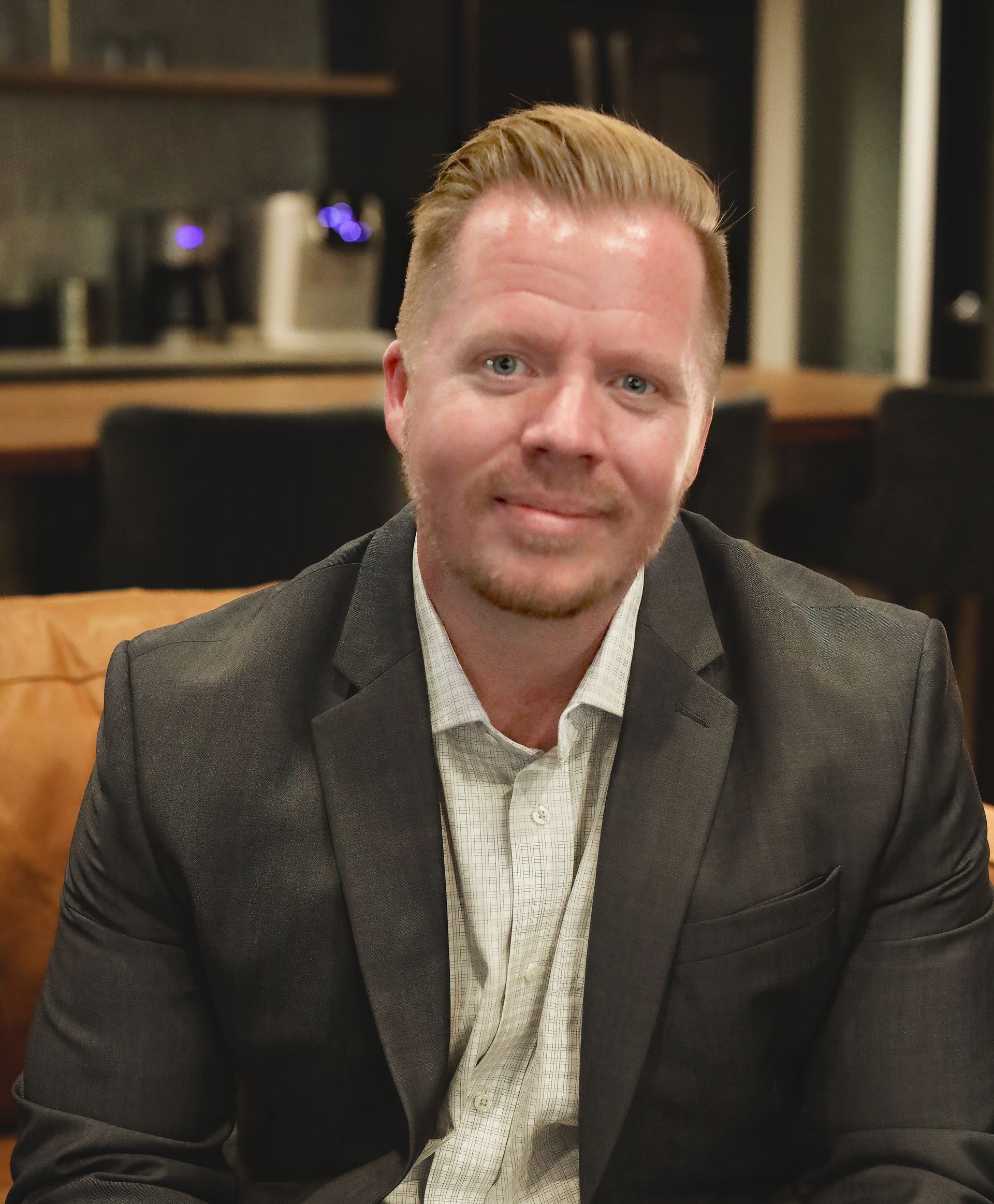 A man in a suit and tie is smiling for the camera.