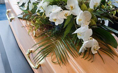 personalised coffin decorated with a table flower bouquet