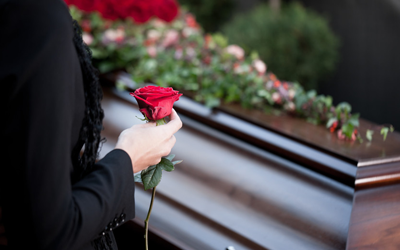 woman holding a rose to place on the coffin