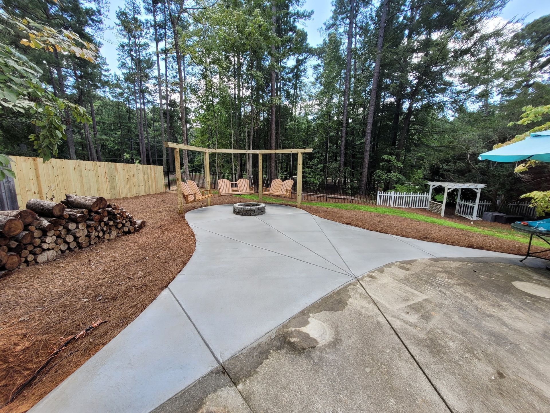 Yellow excavator demolishing a building under a blue sky, grasping debris with claw.