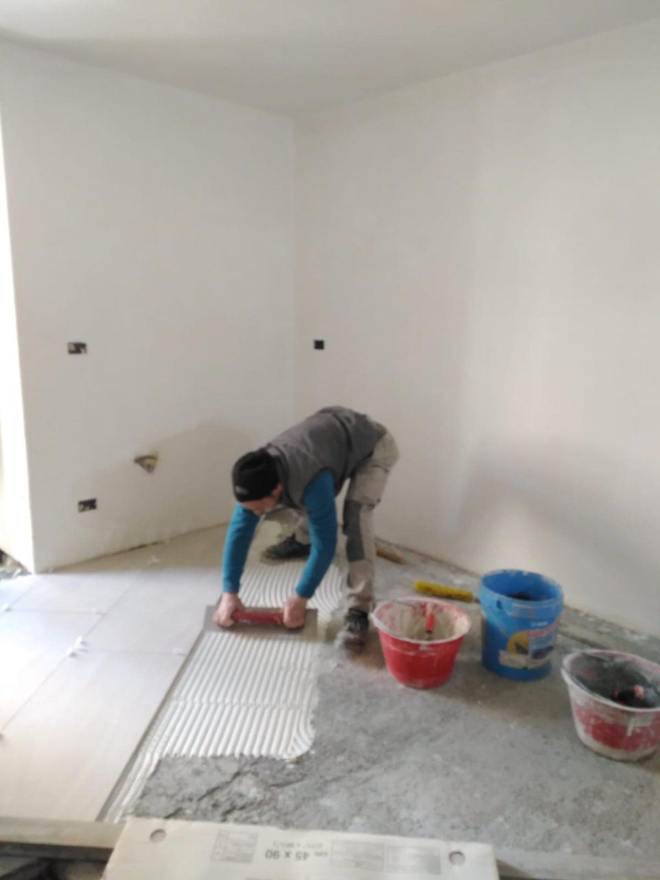 operaio mentre posiziona una pavimentazione