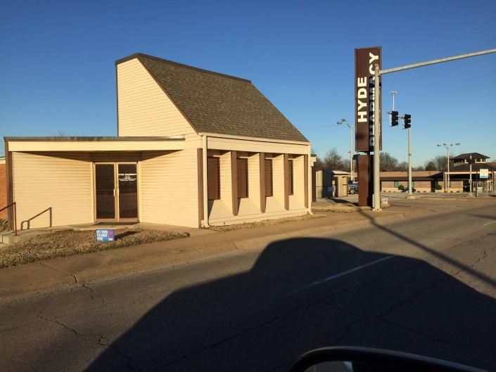 A beige building with a tall, angled roof and a brown sign reading 