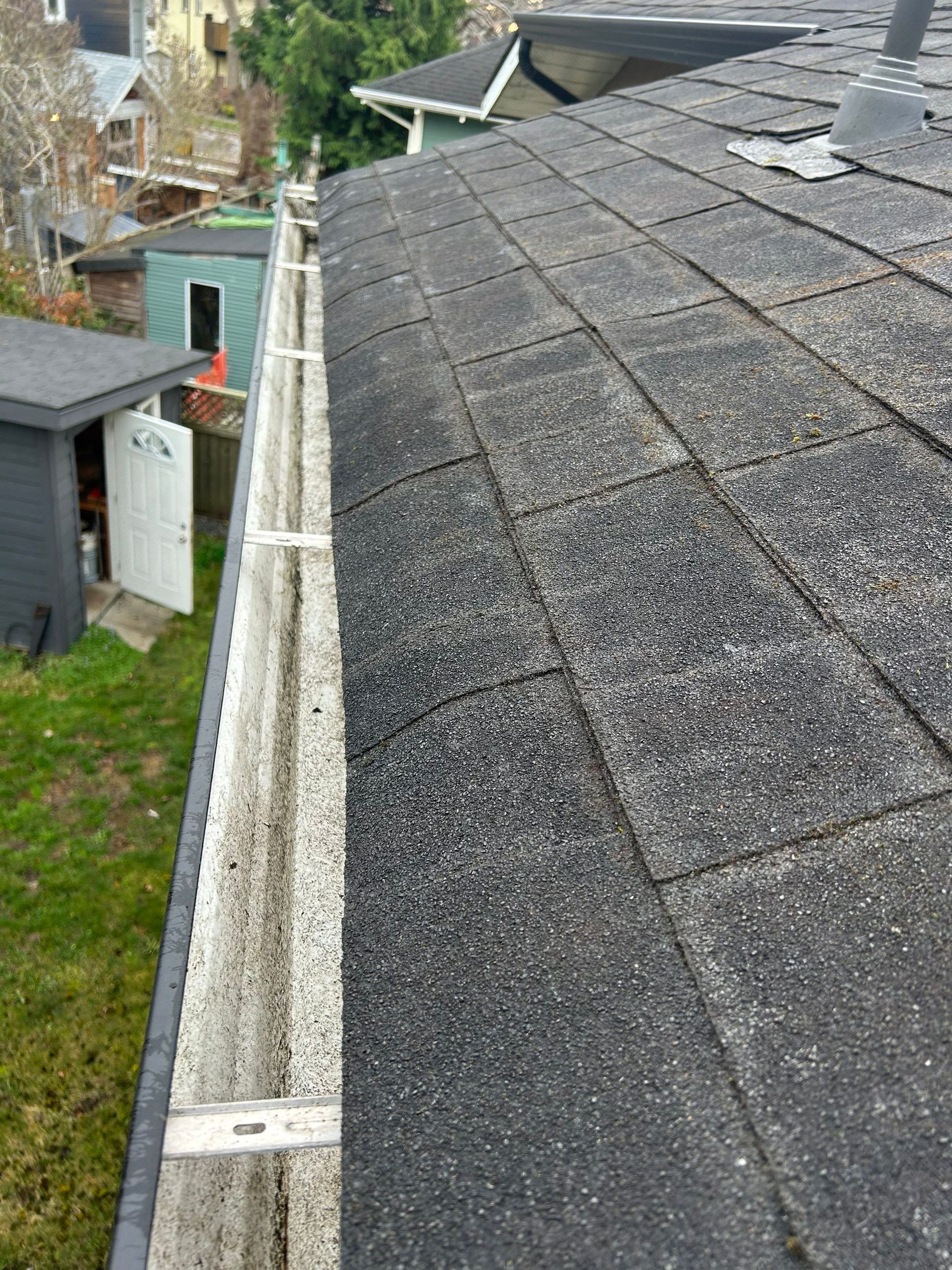 This photo shows a roof and gutters that we cleaned. The before photo is to the left of this one; they're side by side illustrating our services.