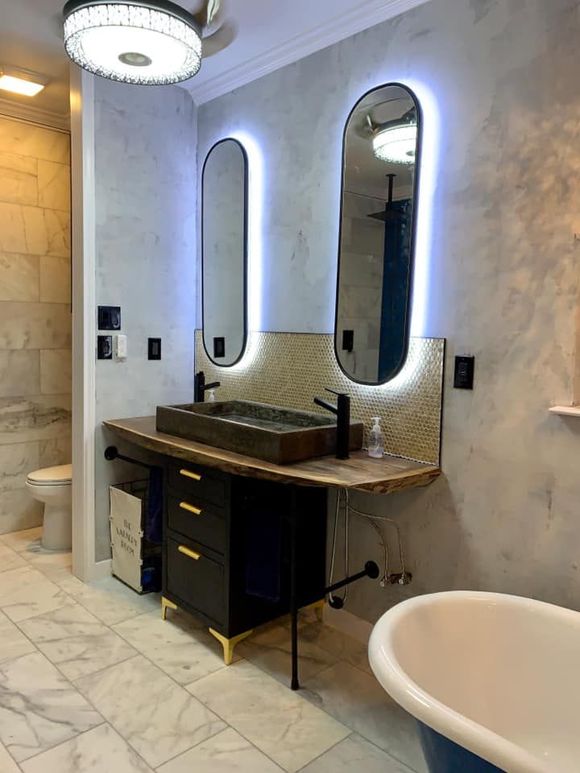 Bathroom with floating vanity, oval mirrors with LED lights, and a clawfoot tub.