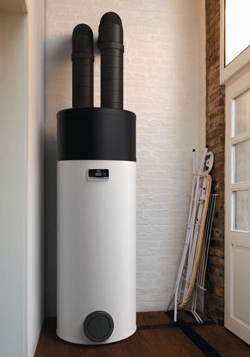 Un grand chauffe-eau thermodynamique, avec une paire de skis appuyés à proximité.