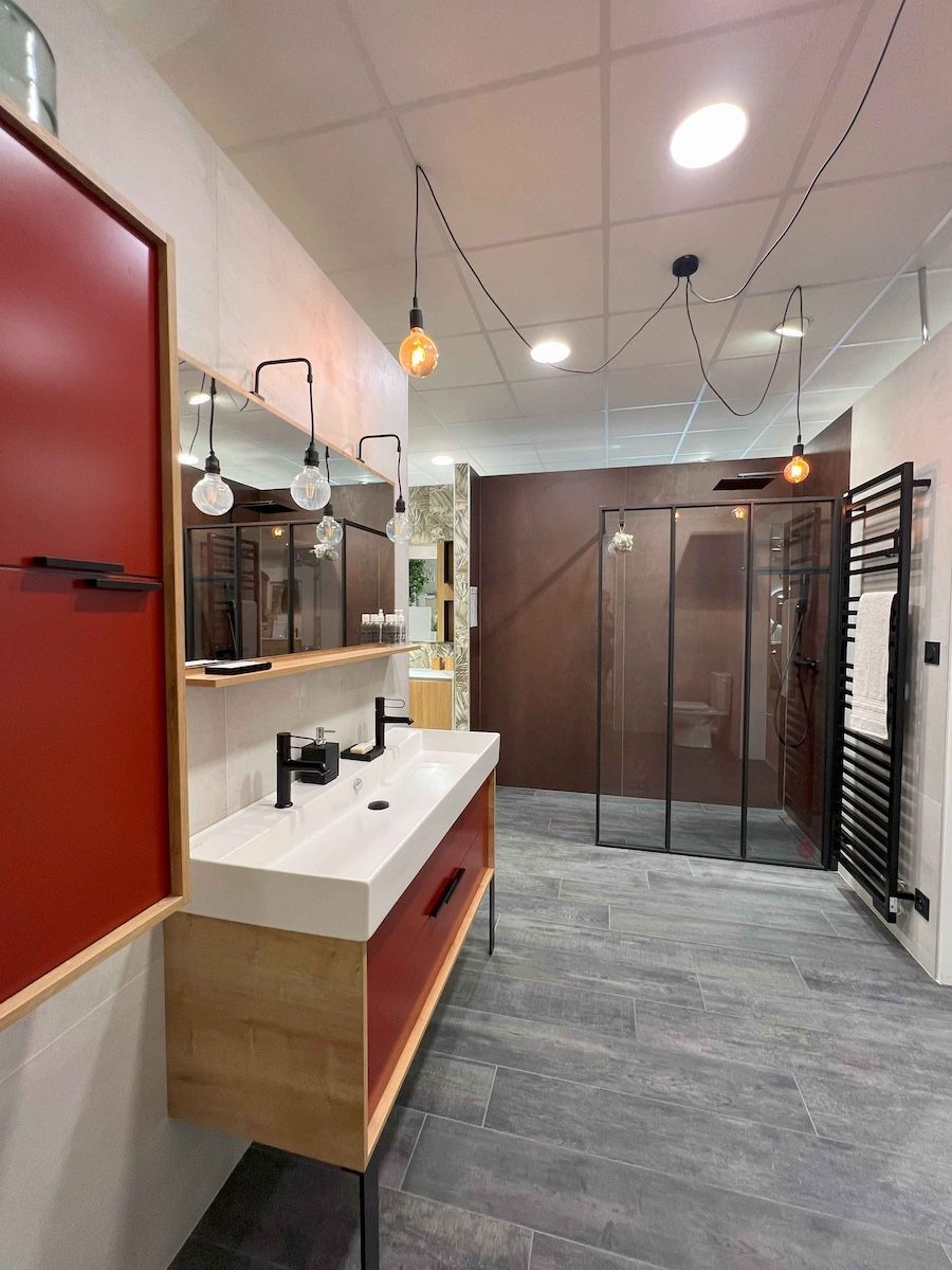 Intérieur de salle de bain moderne avec meuble-lavabo blanc, miroirs, douche en verre et sol carrelé gris