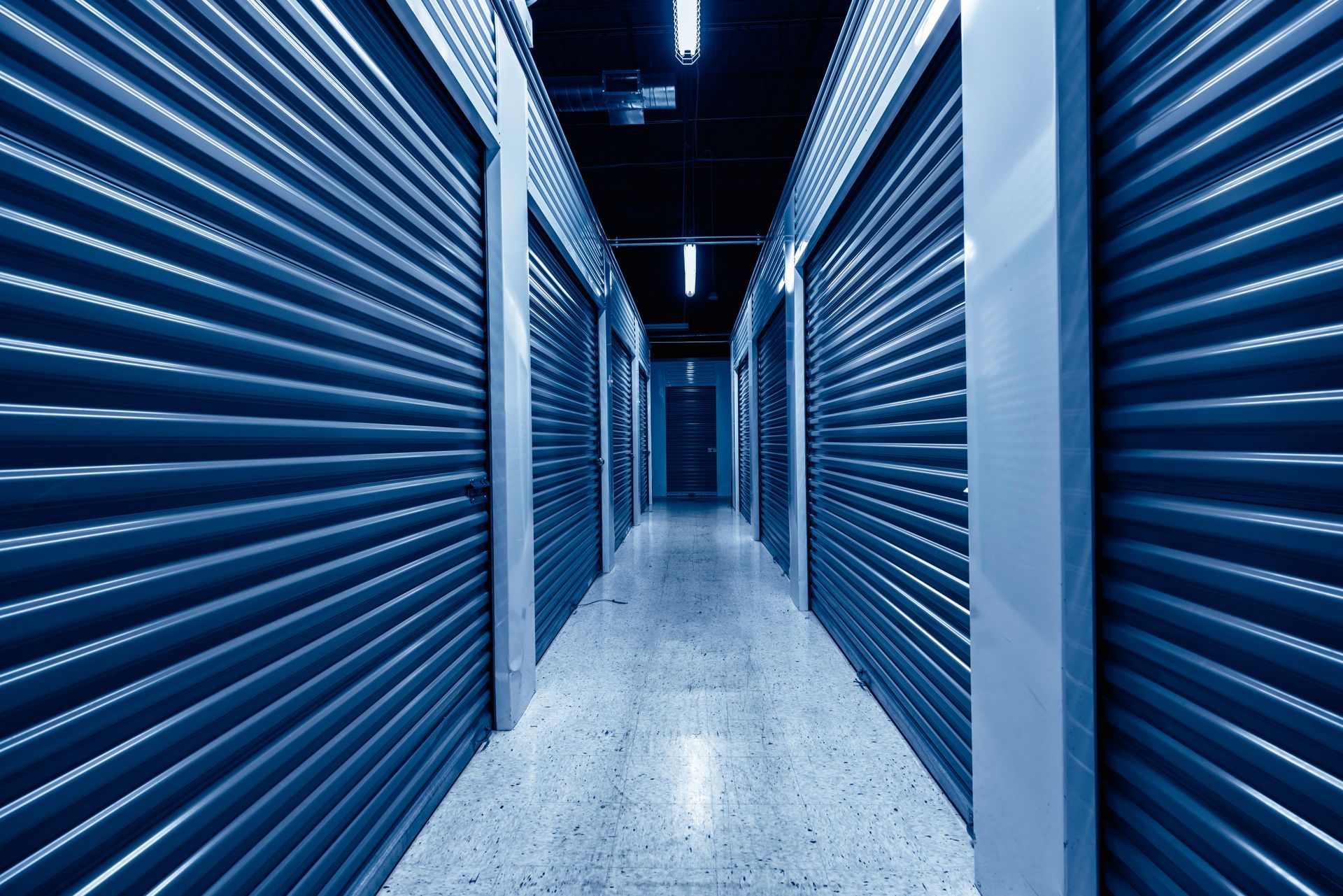 Hallway of storage units with blue metal doors.
