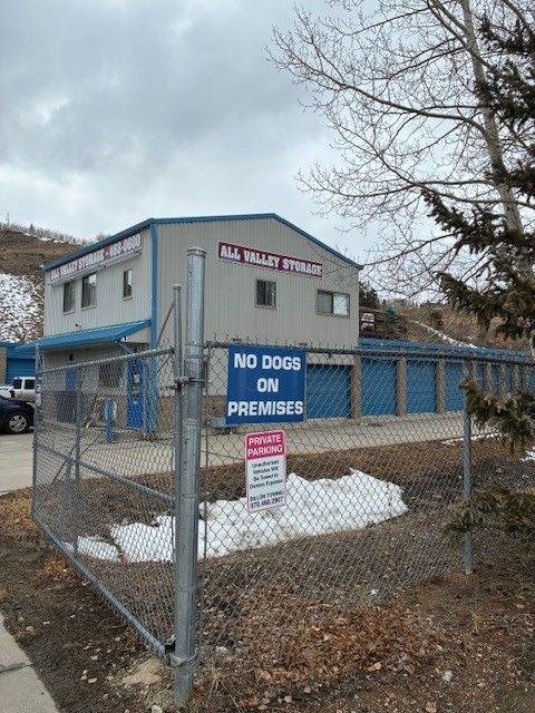 All Valley Storage building with blue storage units. Fence,
