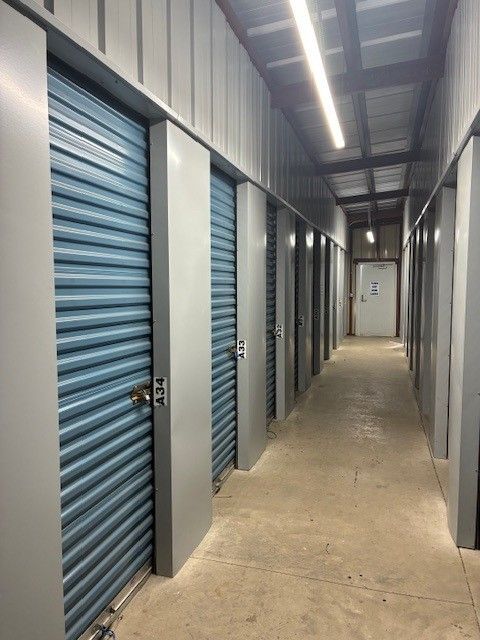 Storage unit hallway with metal doors and windows.