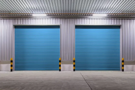 Storage units hallway; boxes and furniture are inside of open unit with green door.
