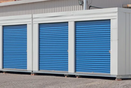 Yellow storage unit interior, open door reveals corrugated metal and brick walls.