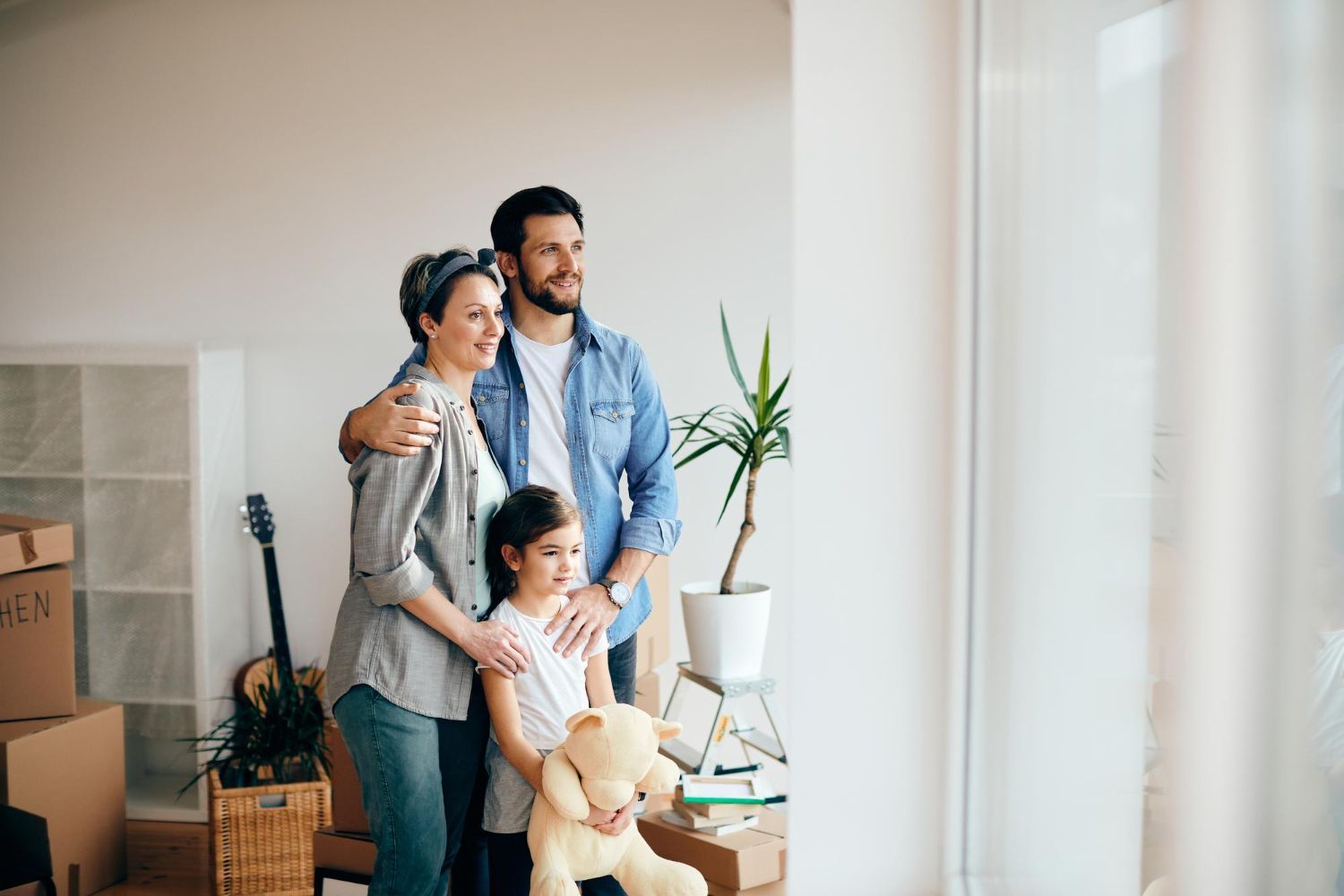 A family is posing for a picture in their new home.